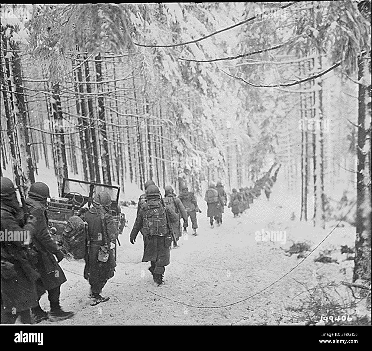 Soldati americani del 289° reggimento di fanteria marciano lungo una strada coperta di neve in Belgio il 24 gennaio 1945, durante la Seconda Guerra Mondiale, per tagliare la strada Saint Vith-Houffalize. Foto Stock