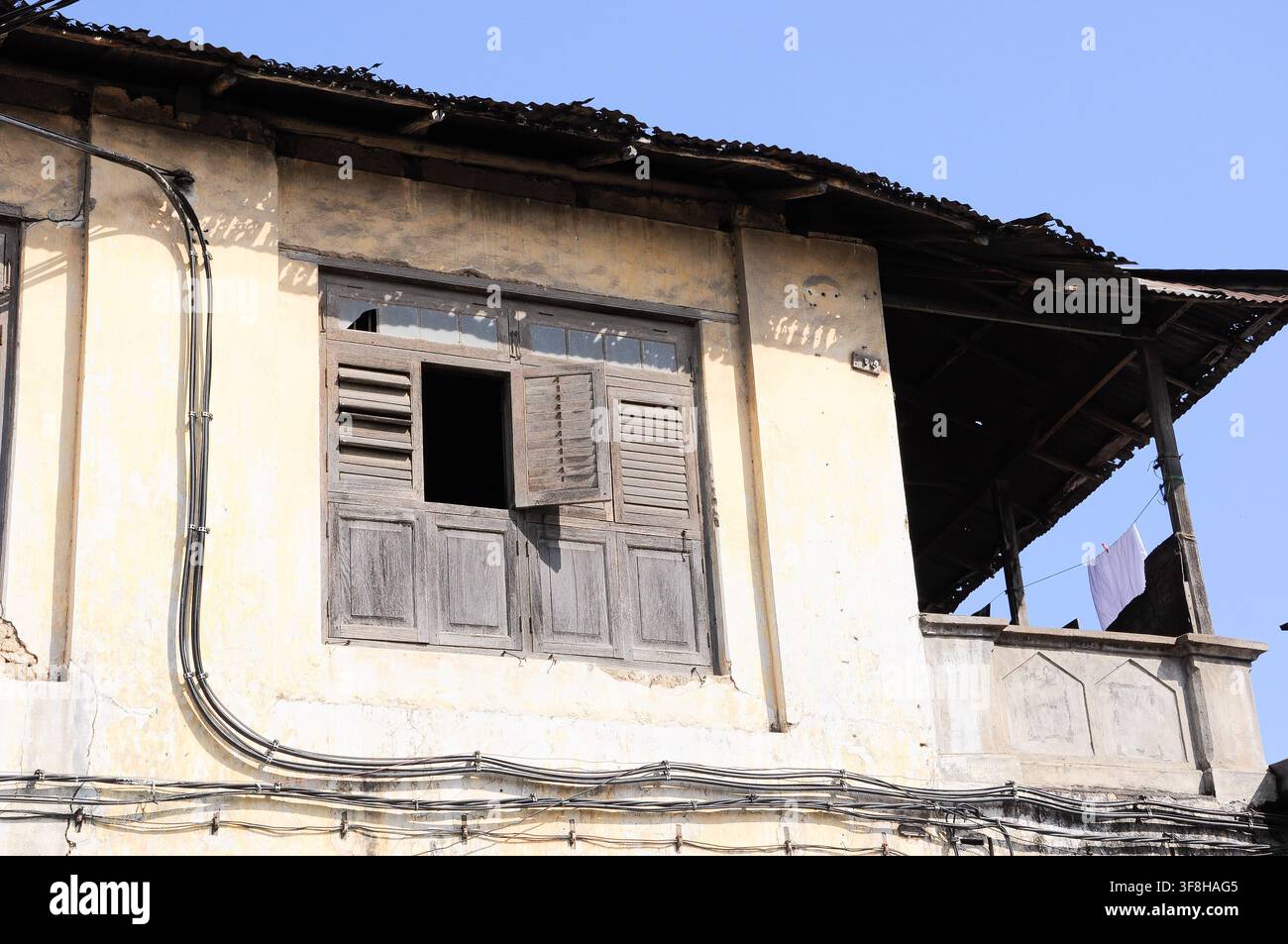 Casa locale a Zanzibar con un cablaggio elettrico scadente e pericoloso appeso all'edificio Foto Stock