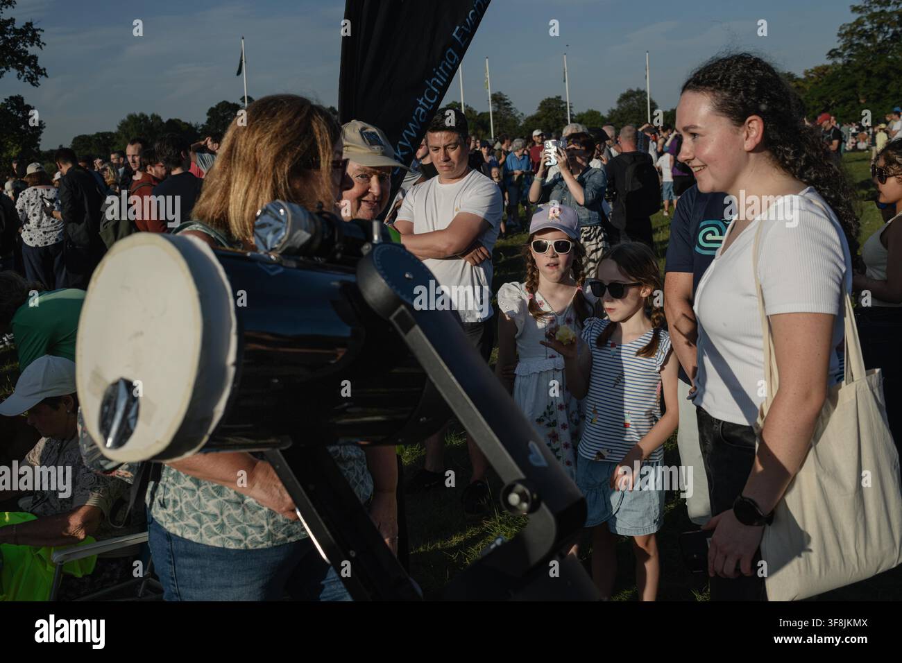 Dublino, Dublino, Irlanda. 12 agosto 2026. Gli spettatori fanno la fila per prendere il proprio turno per osservare l'eclissi solare che si svolge attraverso un grande telescopio nel Phoenix Park di Dublino. Un'eclissi solare parziale ha raggiunto circa il 94% di copertura come vista da Dublino, con gli osservatori che si sono radunati nel Phoenix Park per guardare l'evento sotto un cielo sereno. (Credito immagine: © Graham Martin/ZUMA Press Wire) USO EDITORIALE SOLO! Non per USO COMMERCIALE! Foto Stock