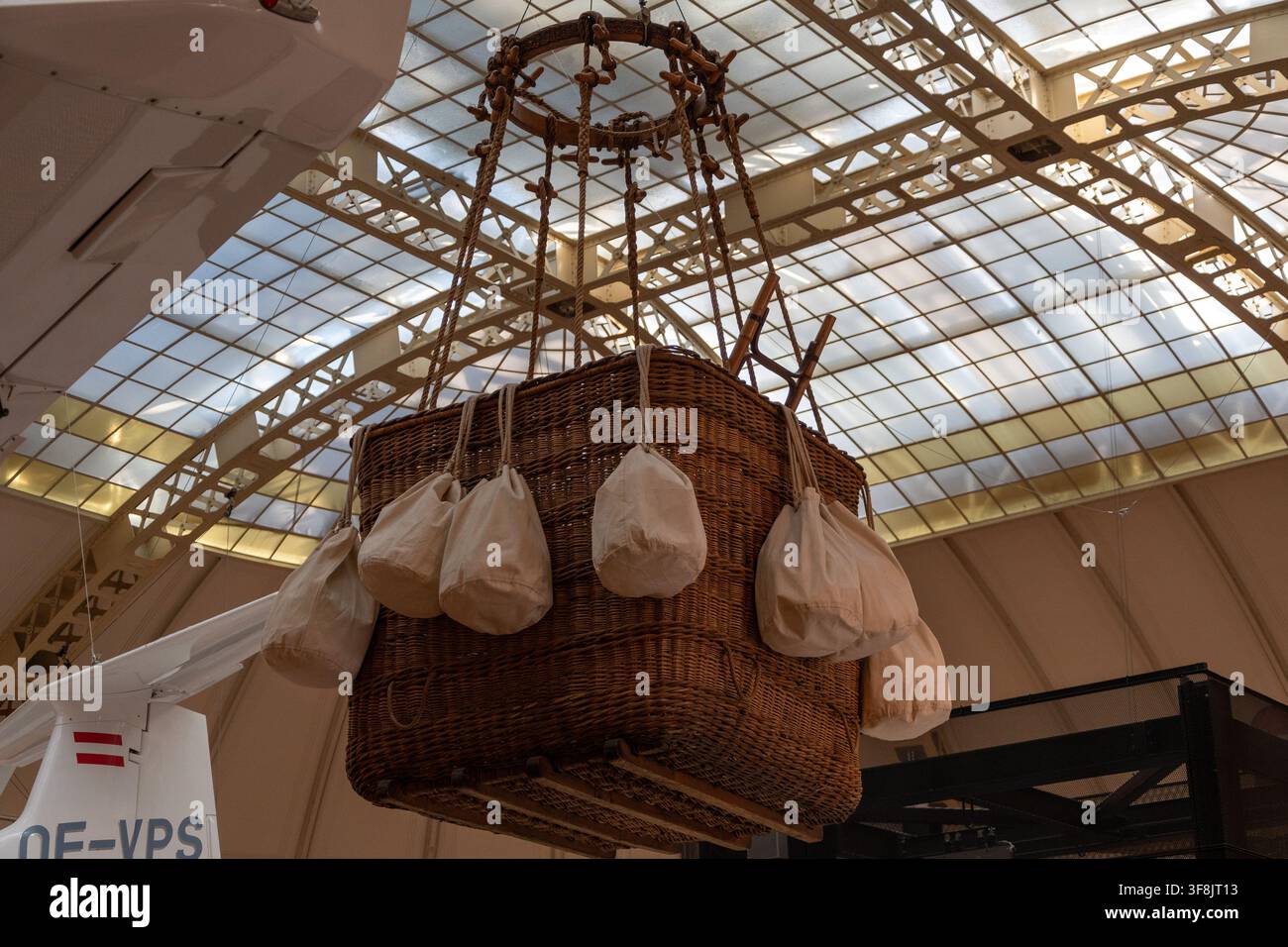 VIENA, AUSTRIA, 7 febbraio 2023: Un cesto di mongolfiera in vimini con sacchi di sabbia appesi è sospeso all'interno sotto un grande tetto in vetro e metallo vicino Foto Stock