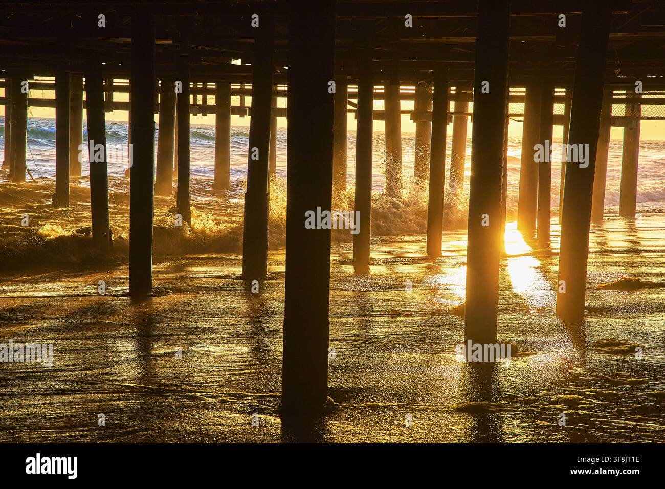 Santa Monica Pier Onde dell'oceano e riflessi della spiaggia dell'ora dorata California Foto Stock