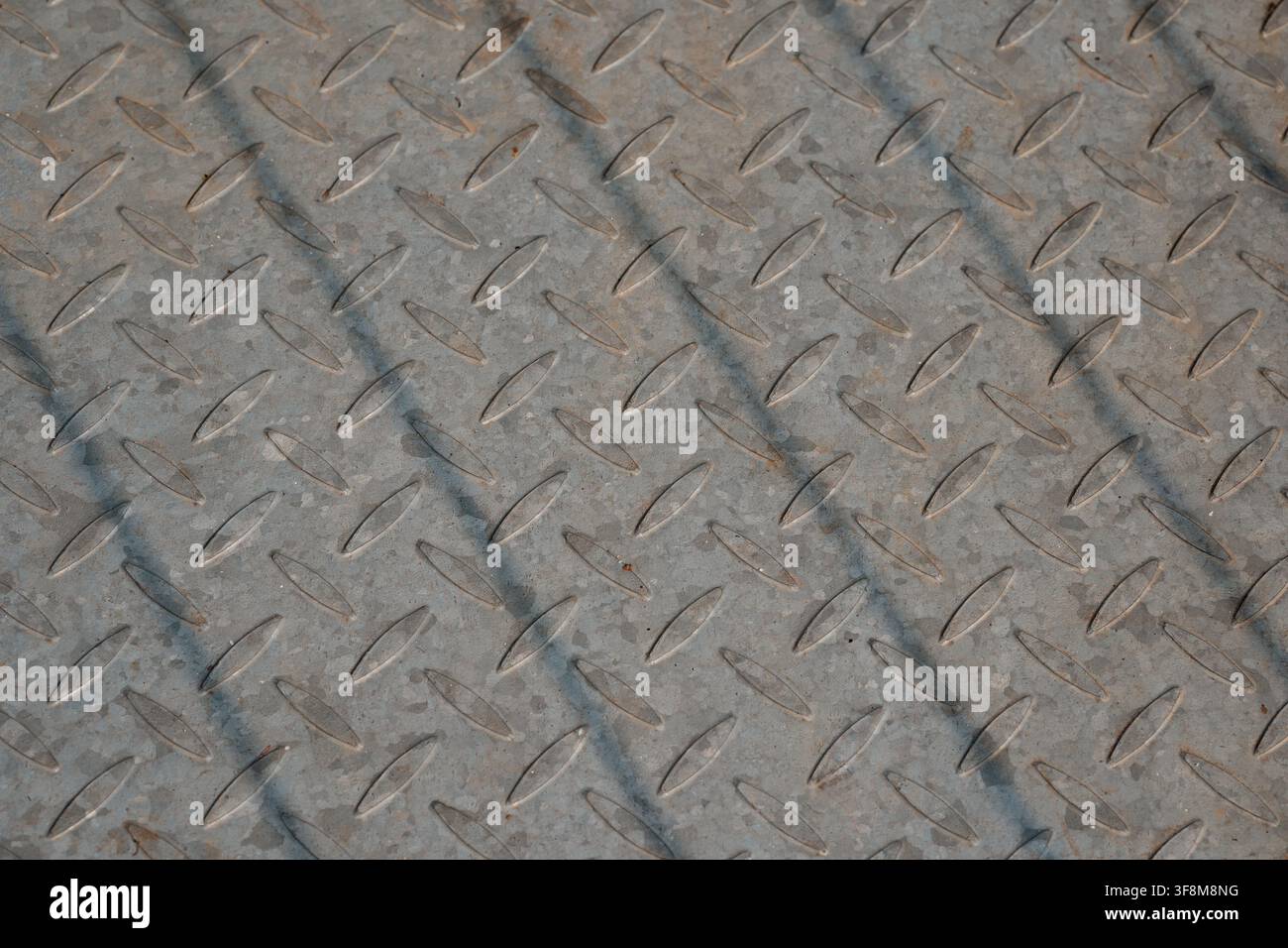 Texture del pavimento in metallo placcato diamantato in acciaio galvanizzato a scacchi con linee d'ombra diagonali. Foto Stock