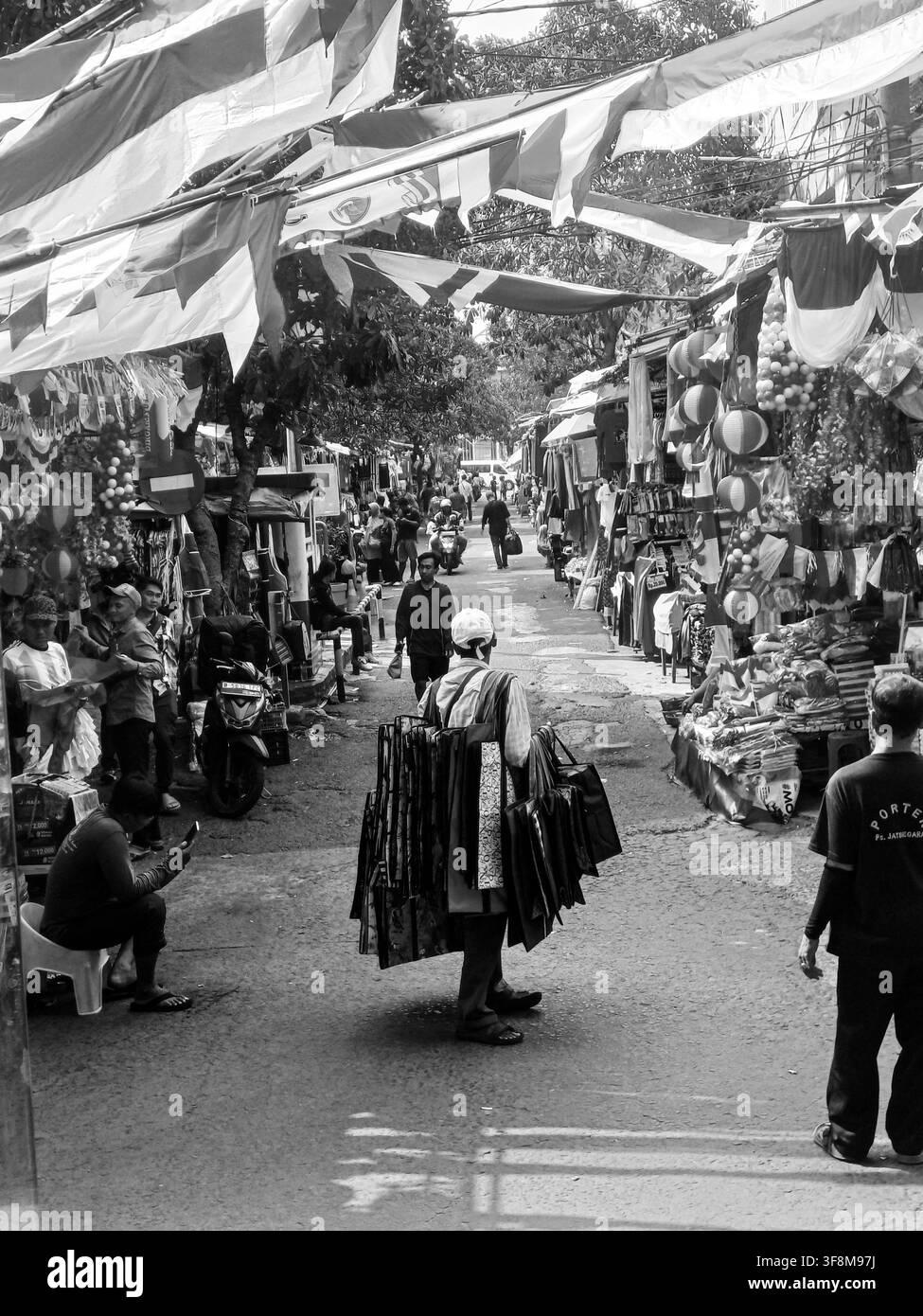 Ritratto verticale in bianco e nero di una venditrice ambulante che cammina in un affollato mercato tradizionale Foto Stock