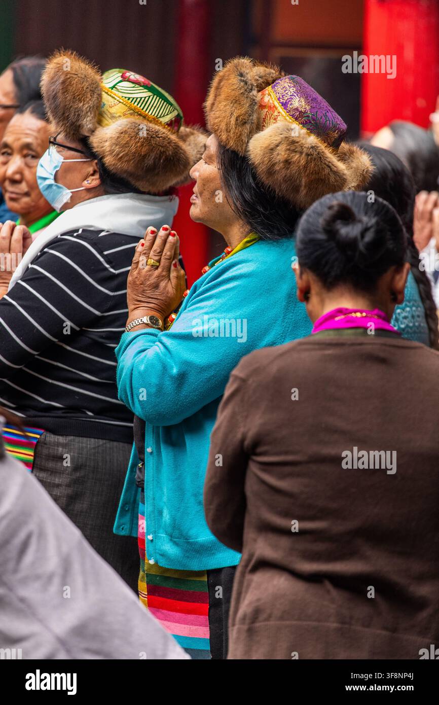 Namche, provincia di Koshi, Nepal - 16 agosto 2022: Vista di persone Sherpa che indossano cappelli tradizionali rifiniti con pelliccia e abiti colorati, che pregano con le mani a Foto Stock