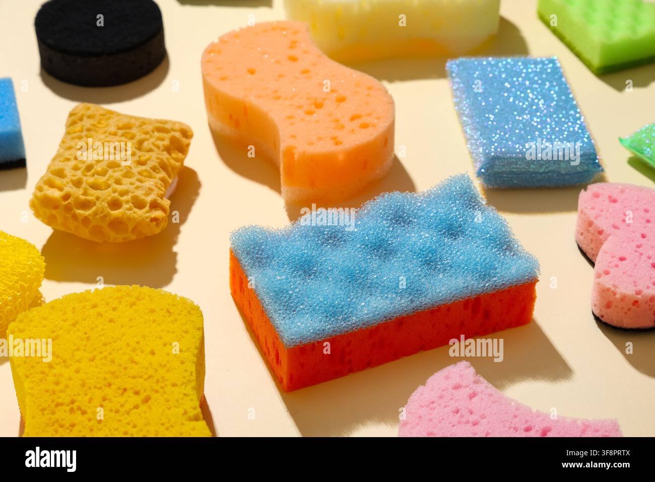 Assortimento di spugne e spazzole da pulizia colorate per le faccende domestiche e il lavaggio dei piatti in cucina Foto Stock