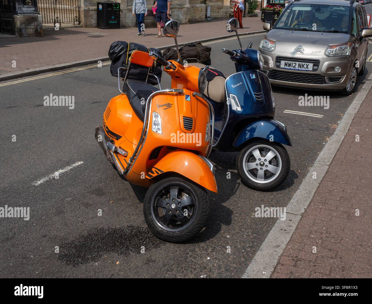 Due scooter Vespa classici parcheggiati su High Street, Stony Stratford, Buckinghamshire, Regno Unito Foto Stock