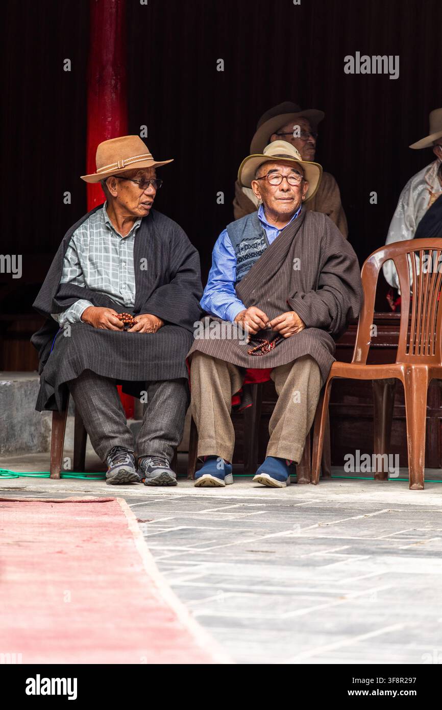 Namche, Provincia di Koshi, Nepal - 16 agosto 2022: Vista di due anziani uomini Sherpa che indossano cappelli e abiti tradizionali mentre tengono delle preghiere durante il Foto Stock
