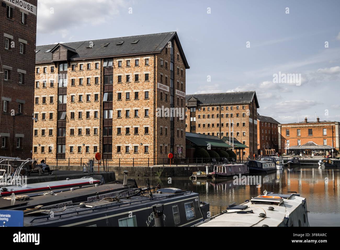 Gloucester, Regno Unito – 21 luglio 2026: Vista degli storici magazzini in mattoni rossi dei Gloucester Docks, con chiatte ormeggiate lungo il canale Foto Stock