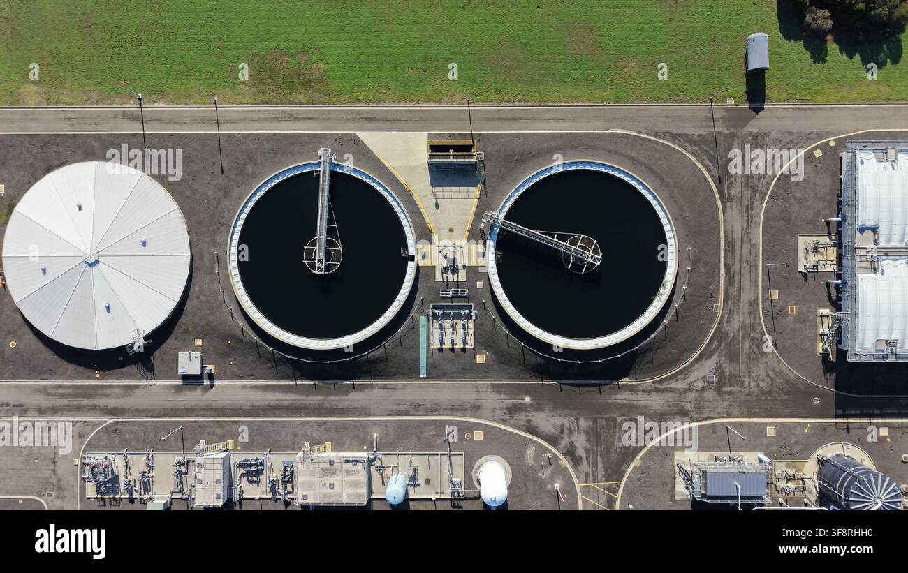 Impianto di trattamento delle acque reflue con grandi clarificatori circolari e infrastrutture, che mostra la purificazione dell'acqua e l'impatto ambientale Foto Stock
