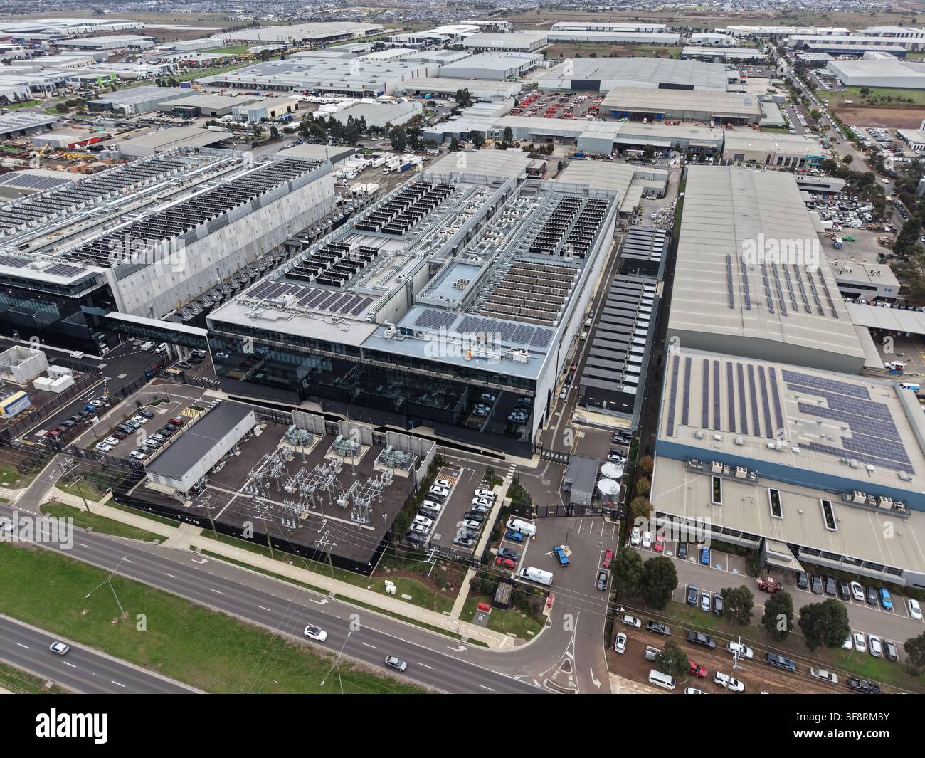 Vista aerea che mostra un moderno campus di data center all'interno di un parco industriale, con più edifici, pannelli solari e infrastrutture energetiche Foto Stock