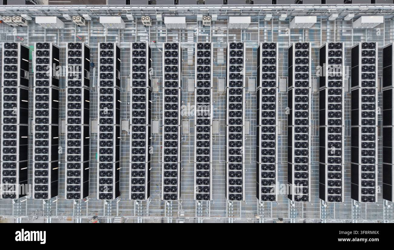 Data center e farm di server moderni che mostrano file di unità di raffreddamento con ventole, parte dell'ampia infrastruttura di archiviazione e networking digitale Foto Stock