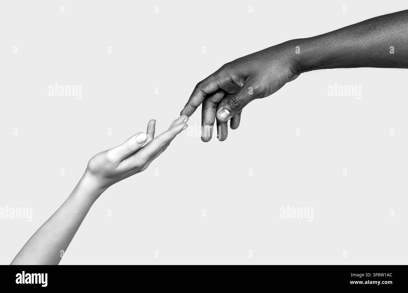 Mani di una donna bianca caucasica e di una donna afroamericana nera che si tengono a dita unite. Bianco e nero Foto Stock