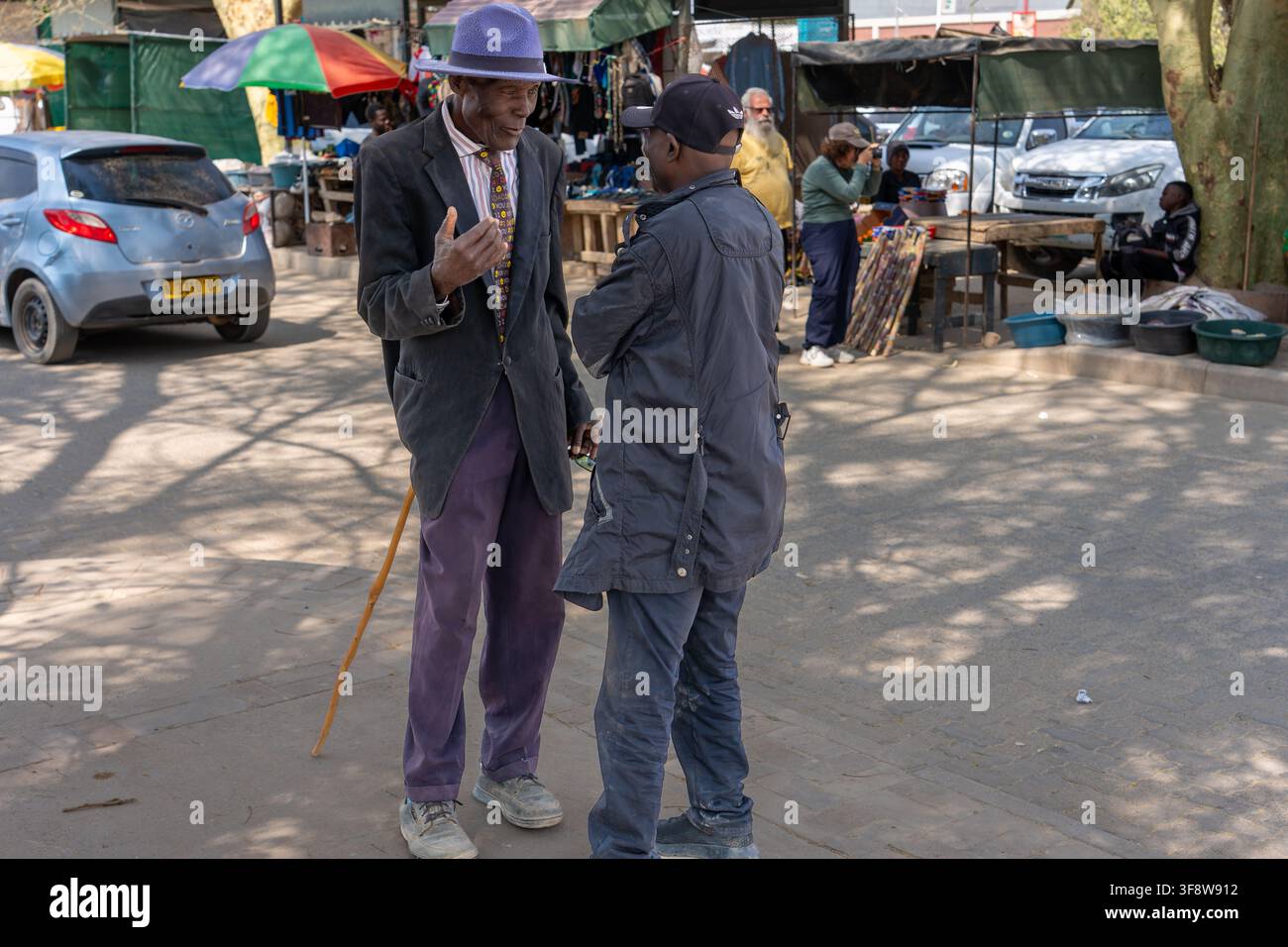 Due uomini anziani chiacchierano in un mercato di strada locale a Opuwo, Namibia. Foto Stock