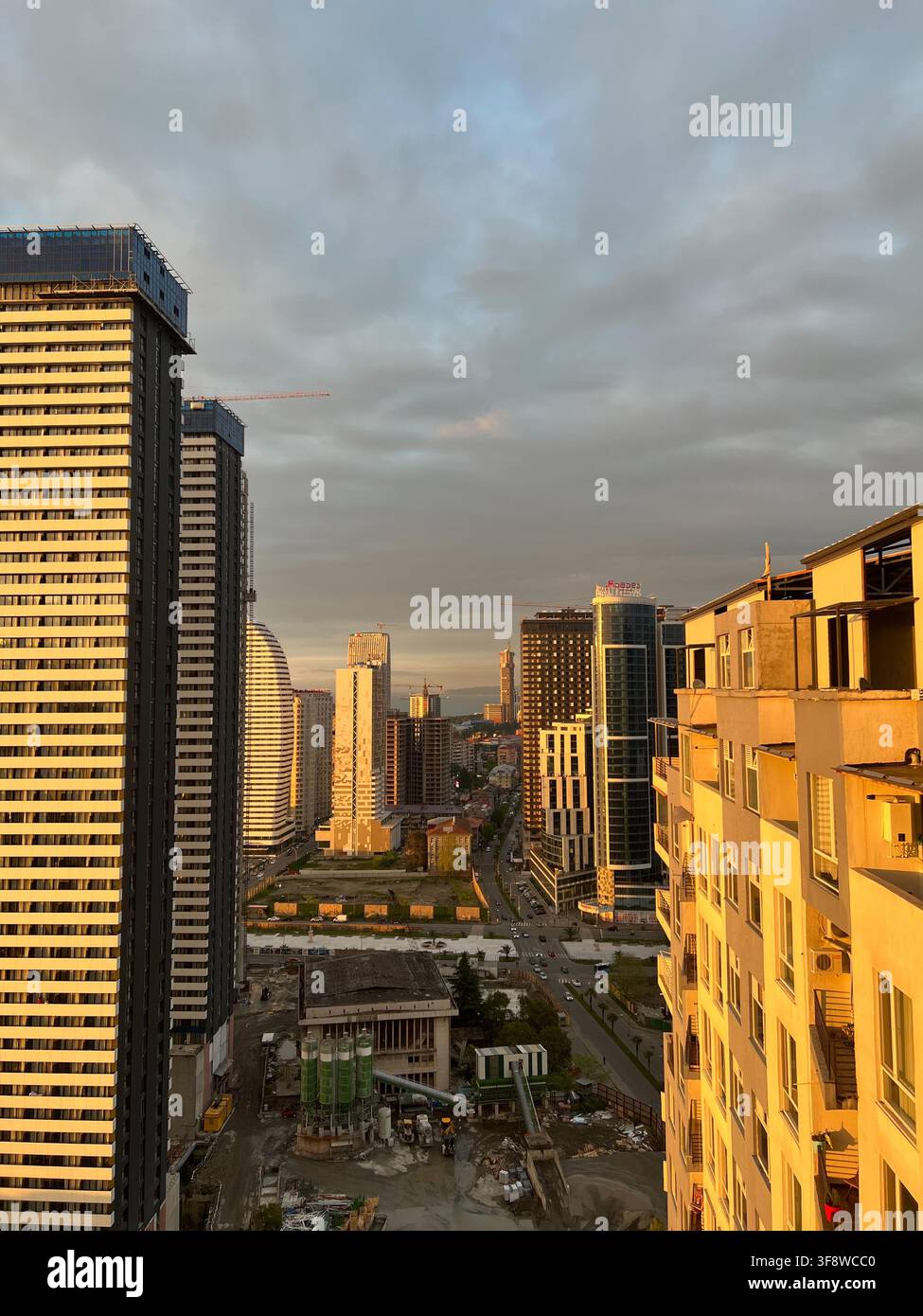Edifici alti in costruzione contro un cielo serale nuvoloso, Batumi, Adjara, Georgia. - Immagine stock catturata con smartphone