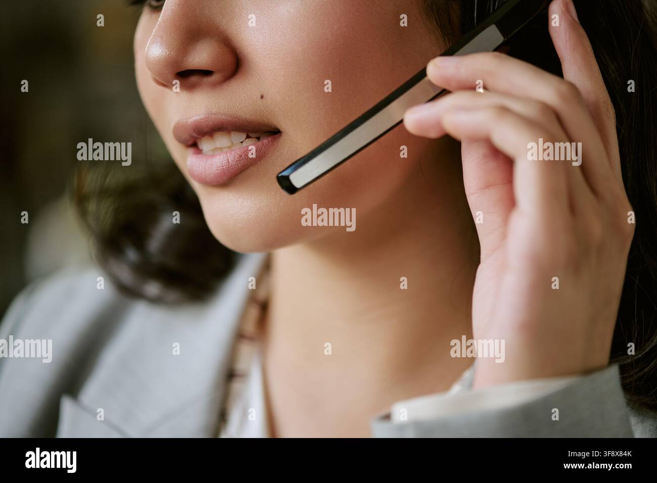 Inquadratura ritagliata di una donna ispanica che parla in un microfono da cuffia Foto Stock
