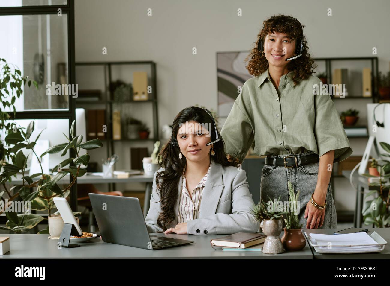 Ritratto di una squadra femminile diversificata di helpdesk che sorride alla telecamera Foto Stock