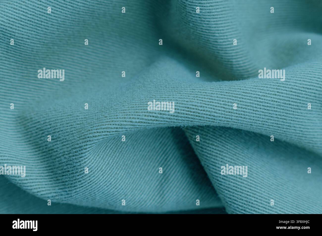 Texture macro di tessuto di cotone lavorato a maglia verde menta con pieghe e increspature morbide sfondo dettagliato per l'industria della moda spazio di copia foto stock. Foto Stock