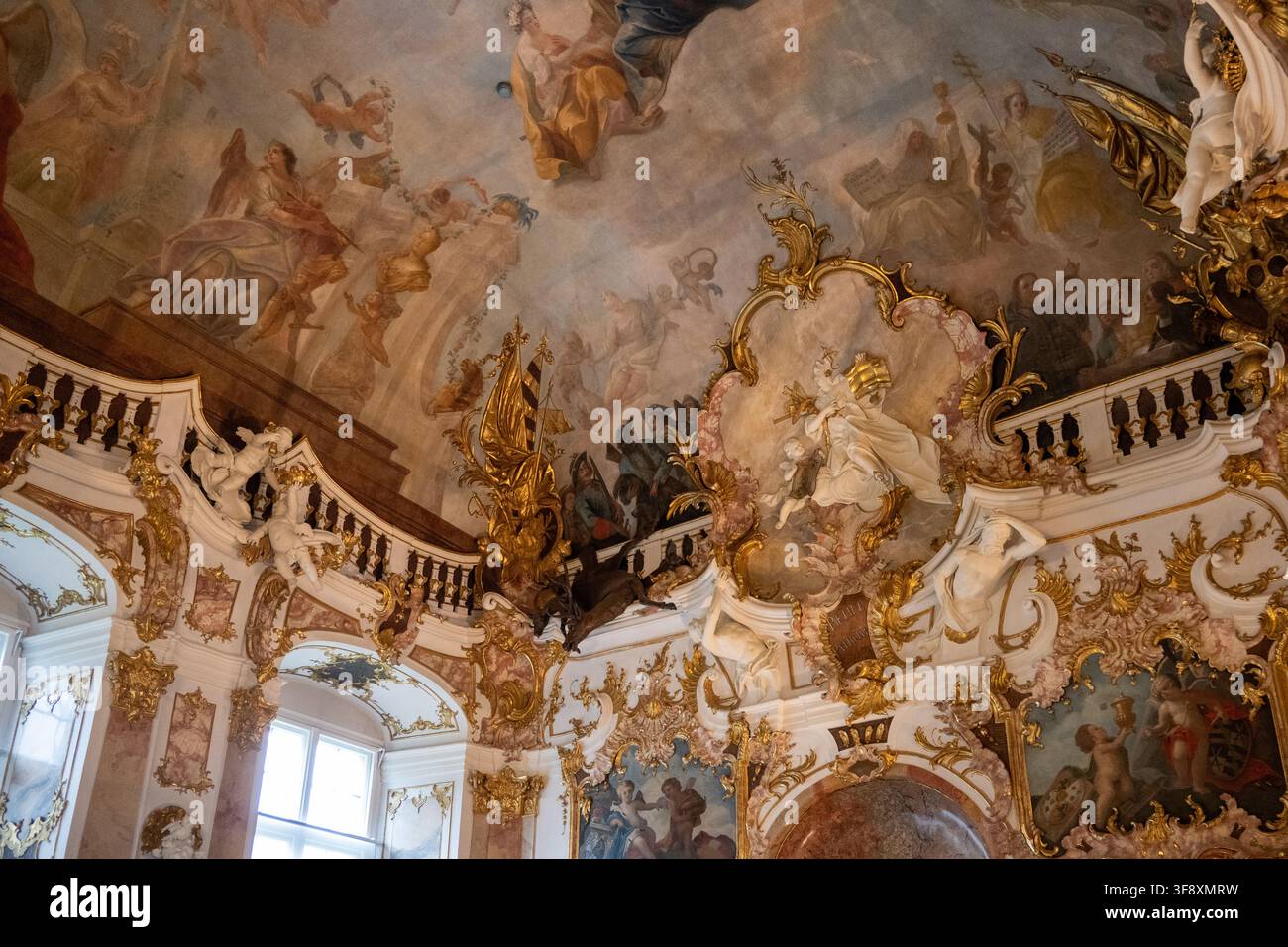 Kempten, Germania - 26 lug 25: Vista ravvicinata di un affresco barocco a soffitto e stucco rococò dorato all’interno della Residenza di Kempten, in Baviera, evidenziando hi Foto Stock