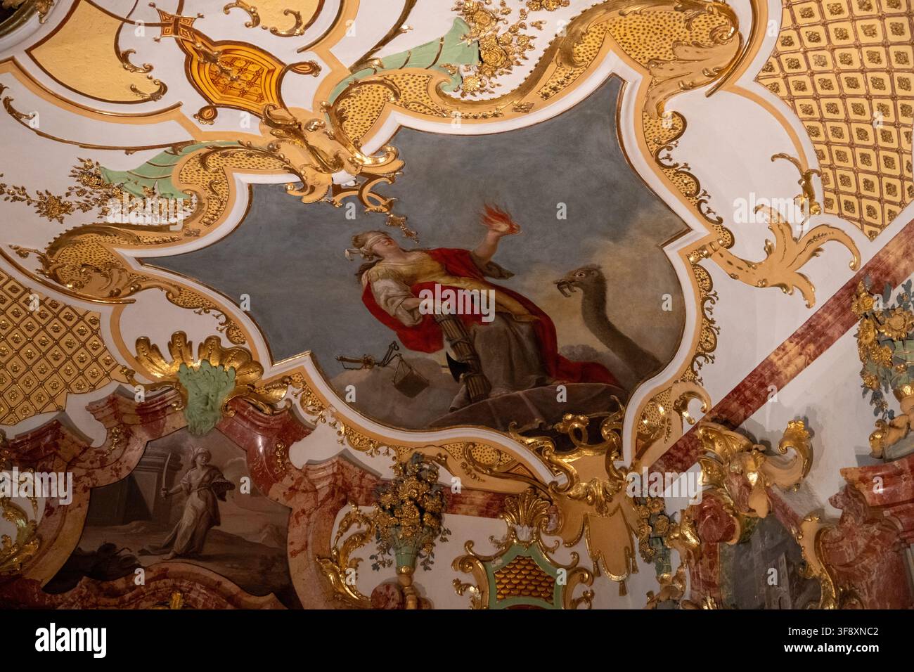 Kempten, Germania - 26 lug 25: Vista dettagliata di un affresco a soffitto rococò incorniciato da stucco dorato e figure allegoriche dipinte alla Residenz Kempten. Foto Stock