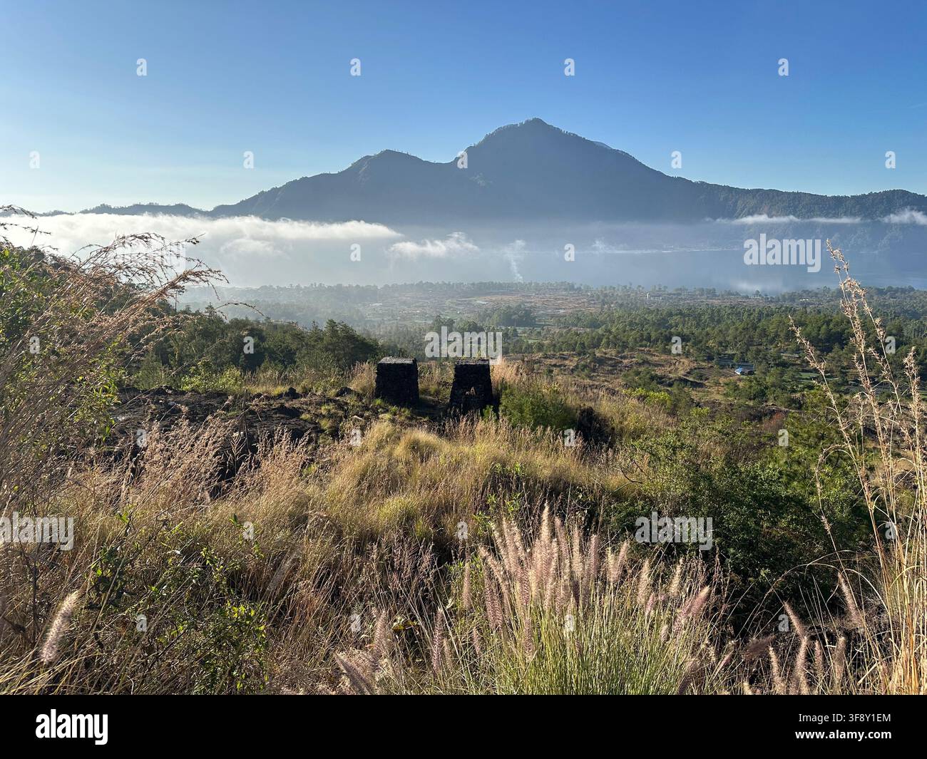 Picco vulcanico che si erge sopra un mare di nuvole, Monte Agung, Bali, Indonesia Foto Stock