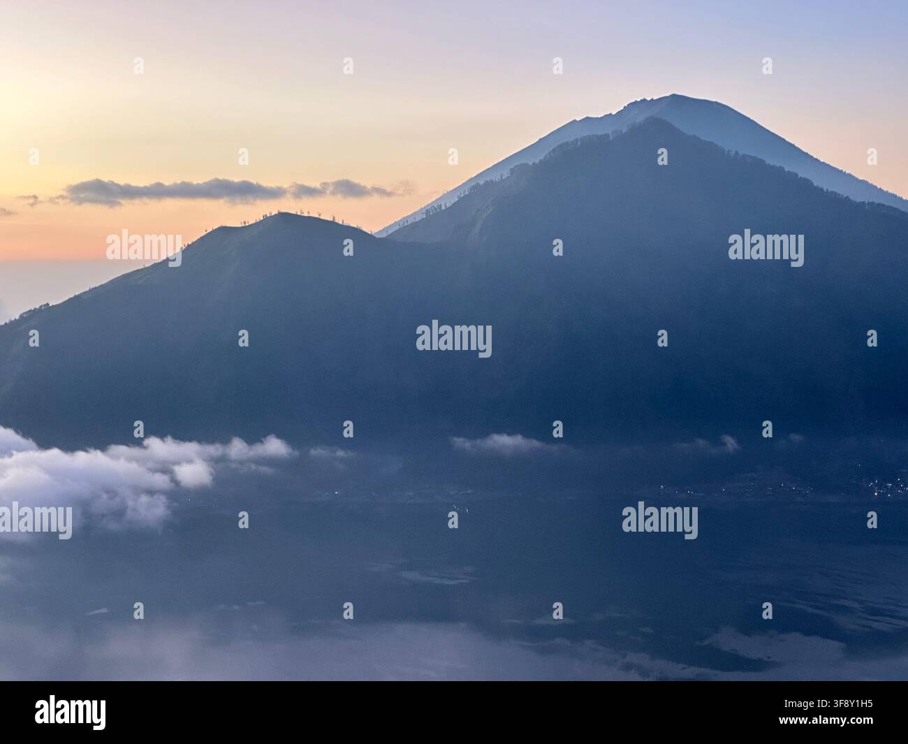 Il monte Agung si erge sopra il mare di nuvole all'alba, Bali, Indonesia Foto Stock