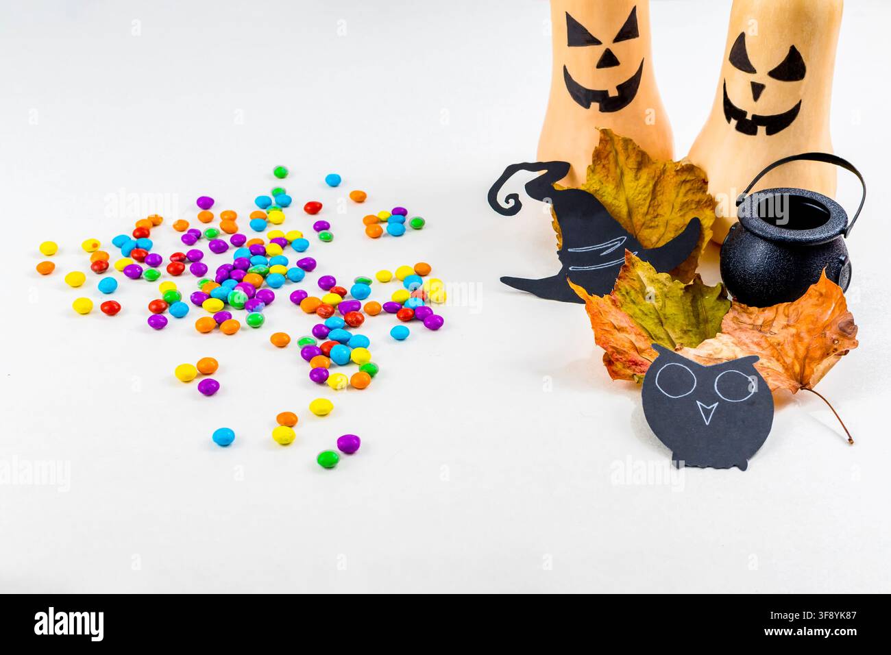 Halloween, zucche, sagome di gufi, polvere colorata, calderone, cappello da strega, su sfondo bianco. Messa a fuoco selettiva. Foto Stock
