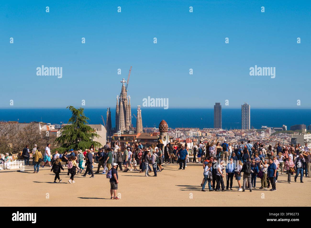 Barcellona, Spagna – 16 aprile 2026: Visitatori sulla terrazza della Sala Ipostila del Park Güell con lo skyline della città all'orizzonte. Foto Stock