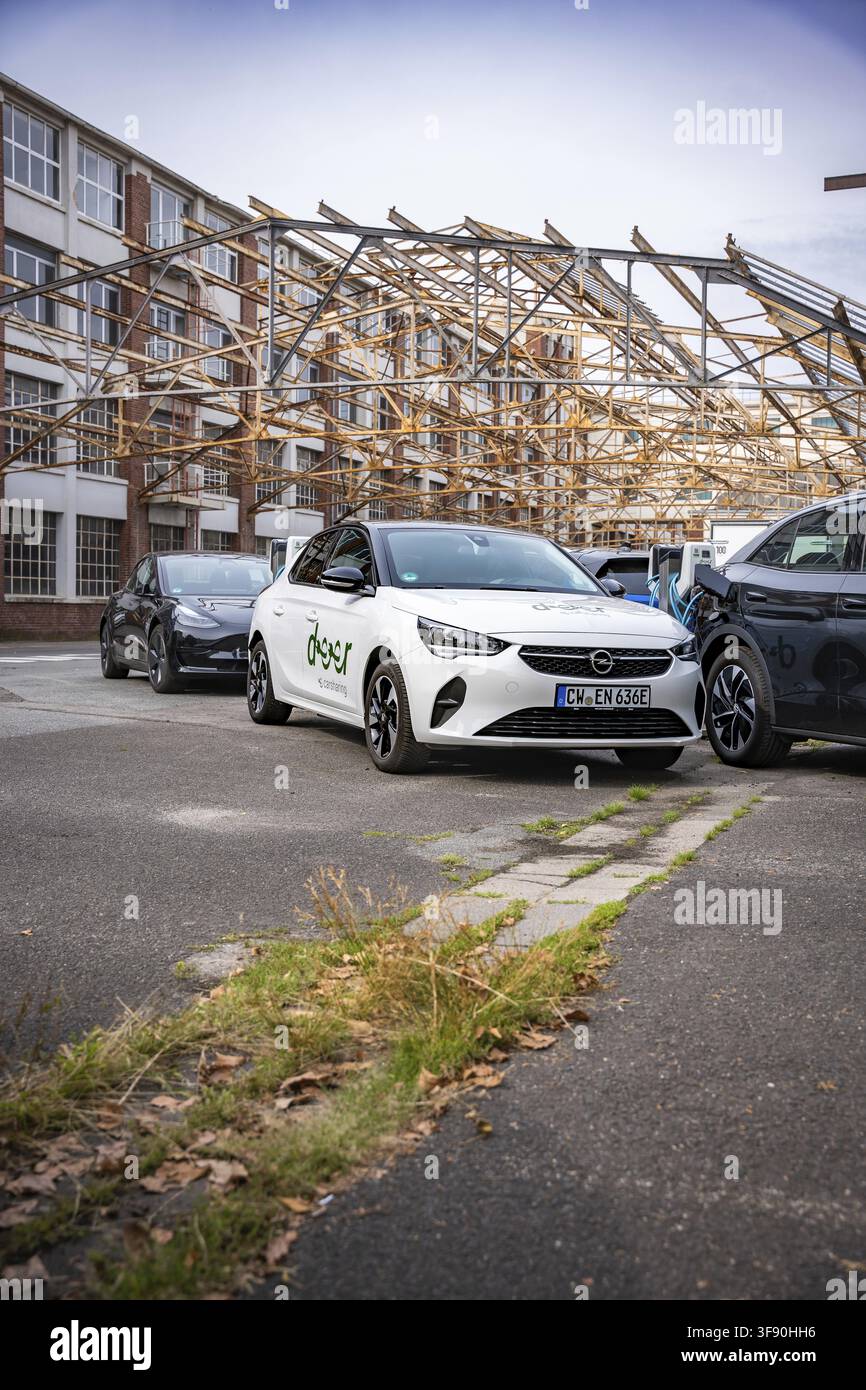 Auto bianche moderne parcheggiate davanti a un edificio parzialmente ristrutturato, parzialmente fatiscente in un'area urbana, Motorworld, Rüsselsheim, Germania Foto Stock