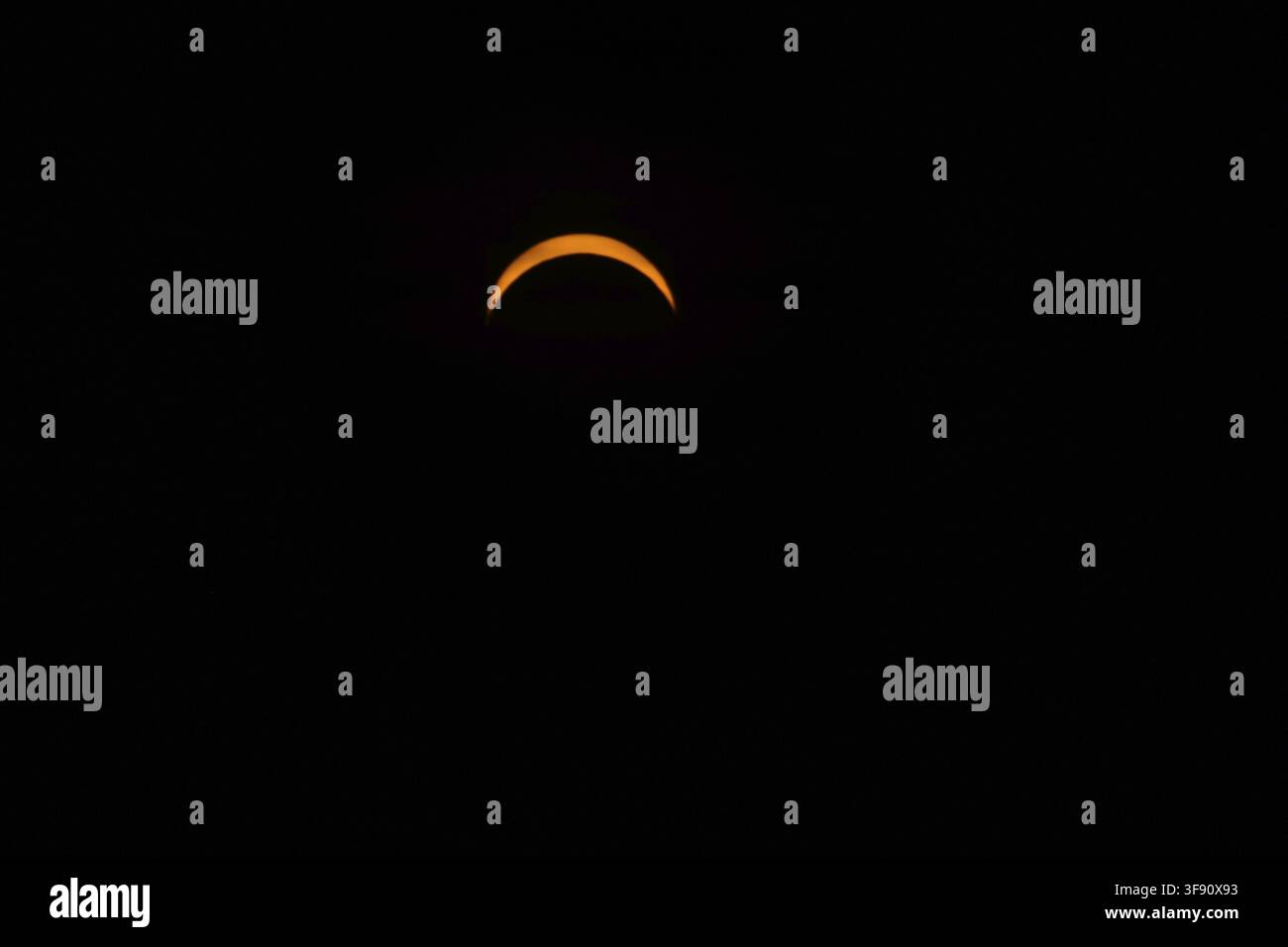 Il Sole è parzialmente oscurato dalla Luna durante l'eclissi solare parziale del 12/08/2026. È sera e il cielo è scuro. Le persone osservano l'e Foto Stock