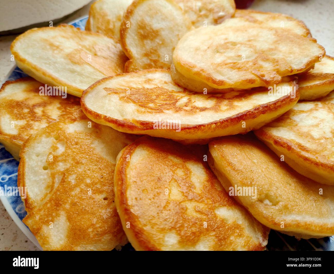 Frittelle tradizionali spesse e soffici, fritte alla perfezione e ammucchiate alte su un piatto per una foto stock della colazione Foto Stock