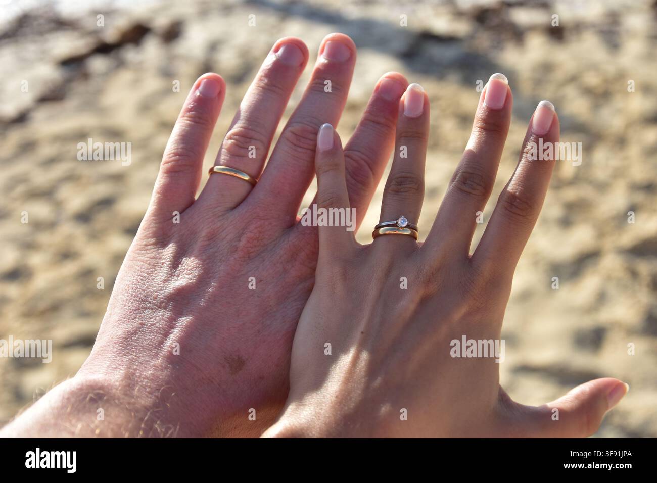 Coppia che mostra gli anelli, simboleggiando amore, impegno e matrimonio Foto Stock