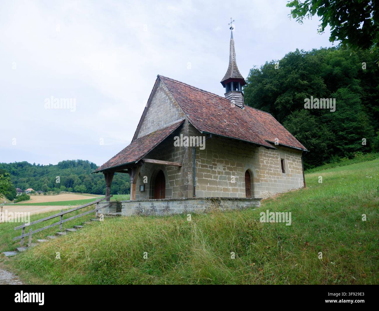 Piccola cappella in pietra su una collina erbosa nella campagna Foto Stock