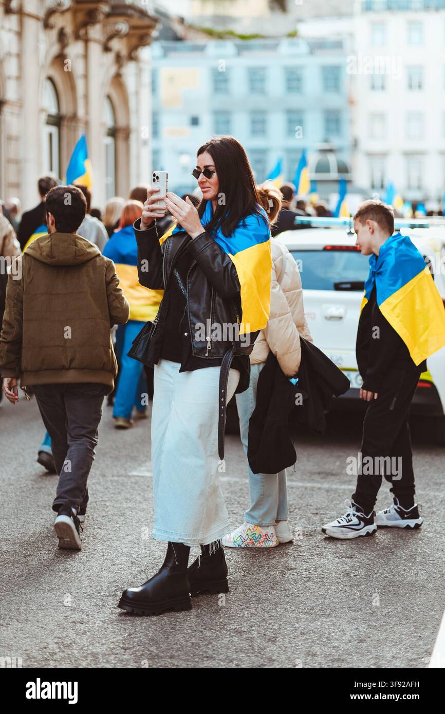 Donna filma con il telefono durante una protesta di solidarietà all'Ucraina Foto Stock