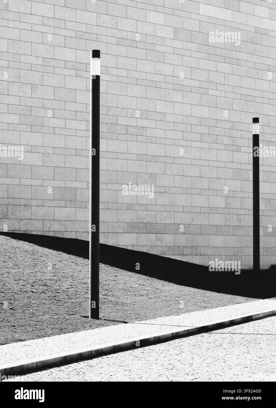 I lampioni minimalisti proiettano lunghe ombre scure Foto Stock
