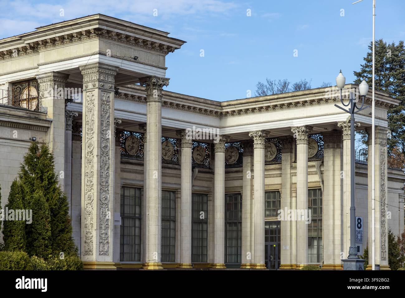 Kyiv, Ucraina - 22 marzo 2026: Facciata ornata di una struttura monumentale in pietra con intricati intagli su pilastri e fregi metallici vintage, rappresentanti c Foto Stock