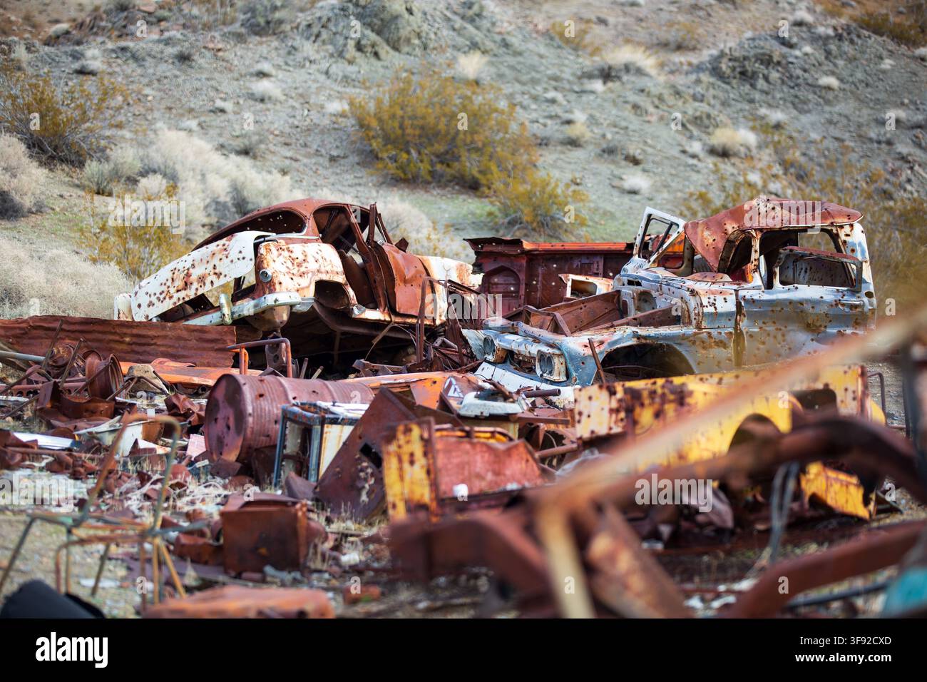 Auto vecchie e arrugginite abbandonate in una discarica del deserto Foto Stock