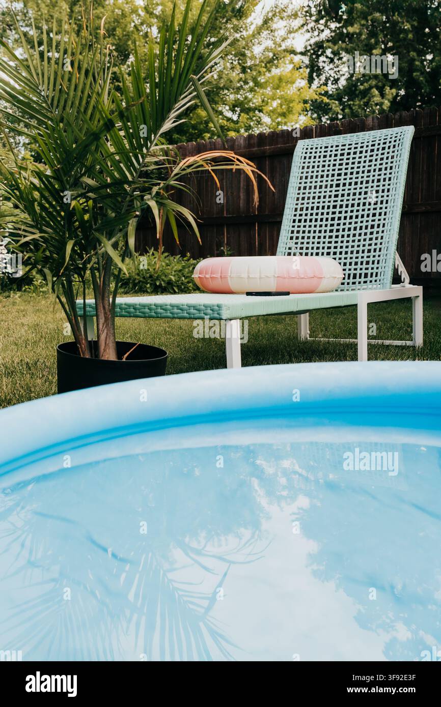 Scena di piscina gonfiabile e sdraio nel cortile Foto Stock