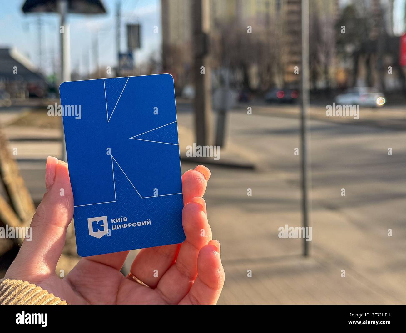 Kyiv, Ucraina - 20 marzo 2026: Persona che tiene una carta di transito digitale blu di Kyiv all'aperto, illustrando comodi sistemi di pagamento elettronici per la metropolitana Foto Stock