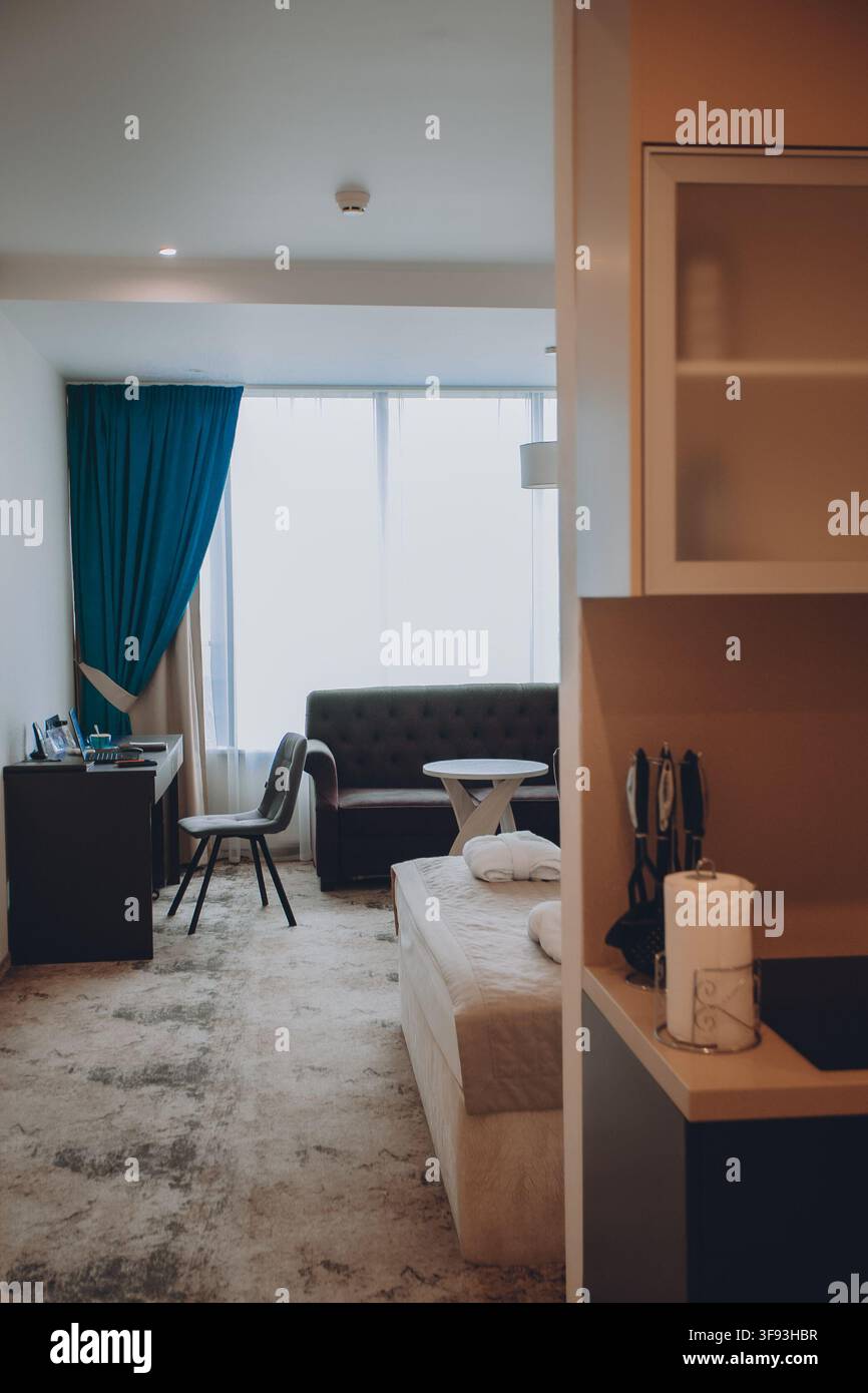 Interno moderno di camera d'albergo con letto, armadio e luce naturale alla finestra Foto Stock