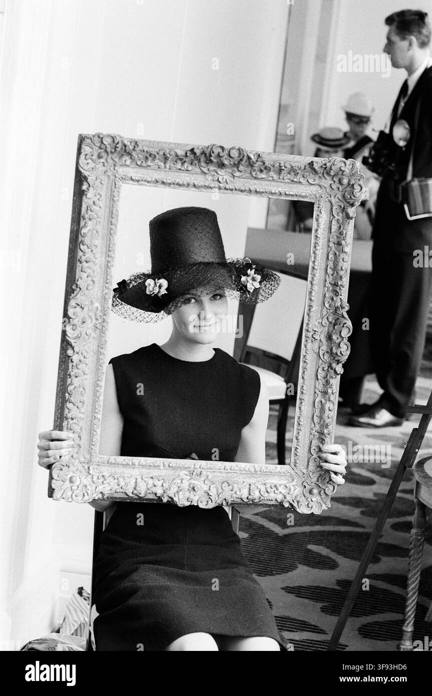 Cappelli primaverili ed estivi del rinomato modista Edward Mann sono stati presentati al Savoy Hotel di Londra martedì 19 febbraio 1963. La modella Lyn Rimmer è ritratta mentre indossa un cappello in stile pellegrino con una corona cilindrica alta ricoperta da una fine rete. La tesa è drappeggiata con una delicata veletta di rete nera. È strettamente incorniciata da una cornice fotografica vintage spessa e finemente intagliata, creando un effetto di immagine nell'immagine. Foto Stock