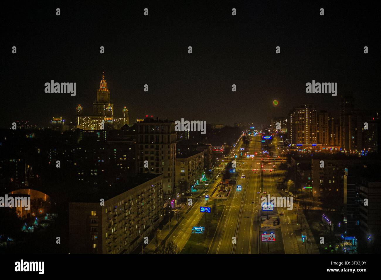 Paesaggio notturno della città con viale illuminato e skyline urbana Foto Stock
