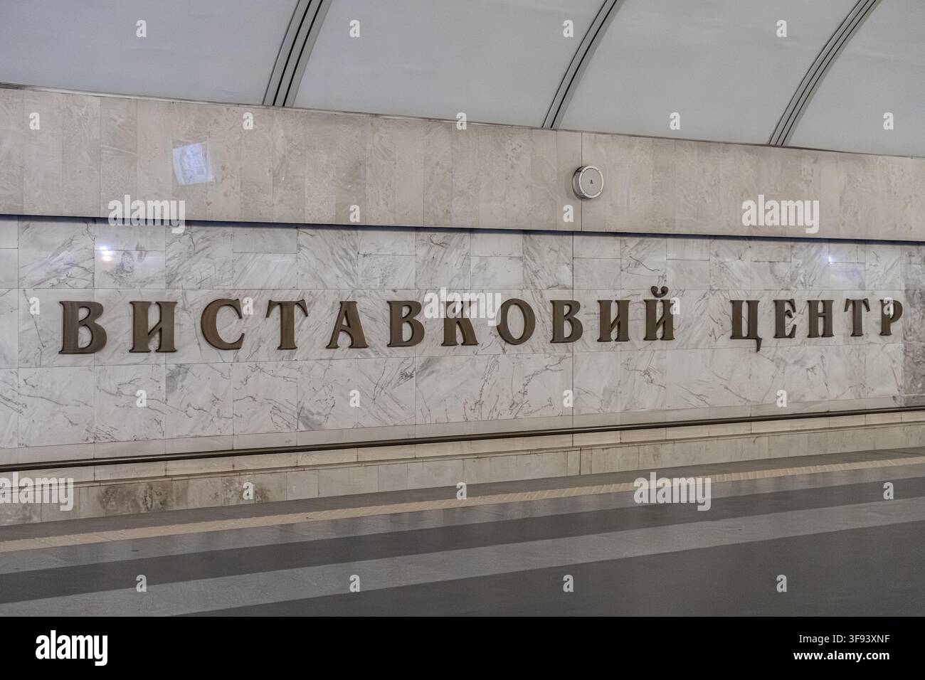 Kyiv, Ucraina - 15 marzo 2026: La segnaletica della metropolitana di Vystavkovyi Tsentr mostra eleganti lettere di bronzo su una parete di marmo bianco lucido, catturando l'unico Foto Stock