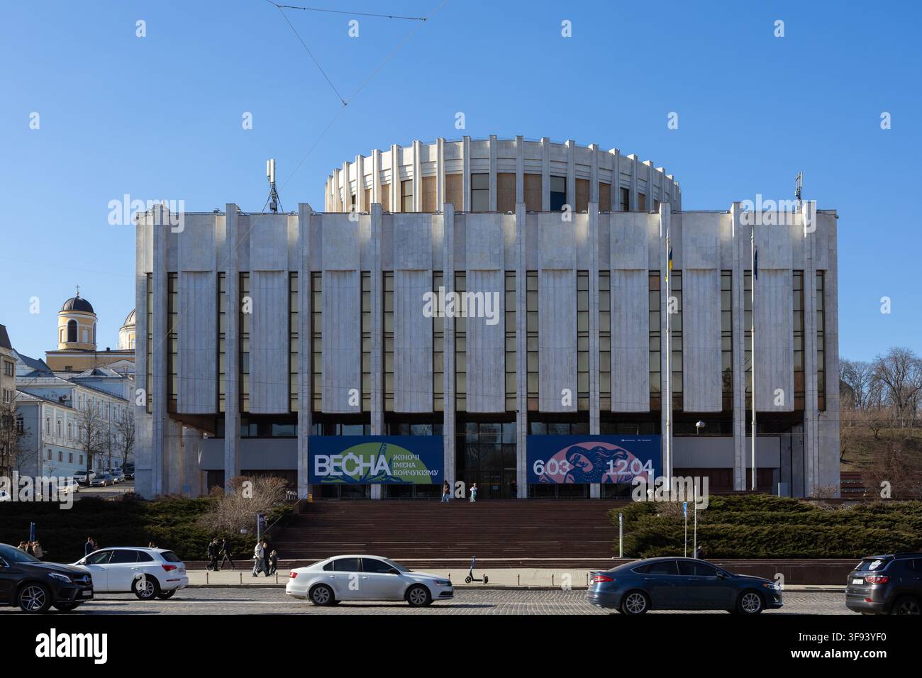 Kyiv, Ucraina - 15 marzo 2026: Esterno architettonico della Casa ucraina con design geometrico in marmo e ampia scalinata con auto che passano Foto Stock