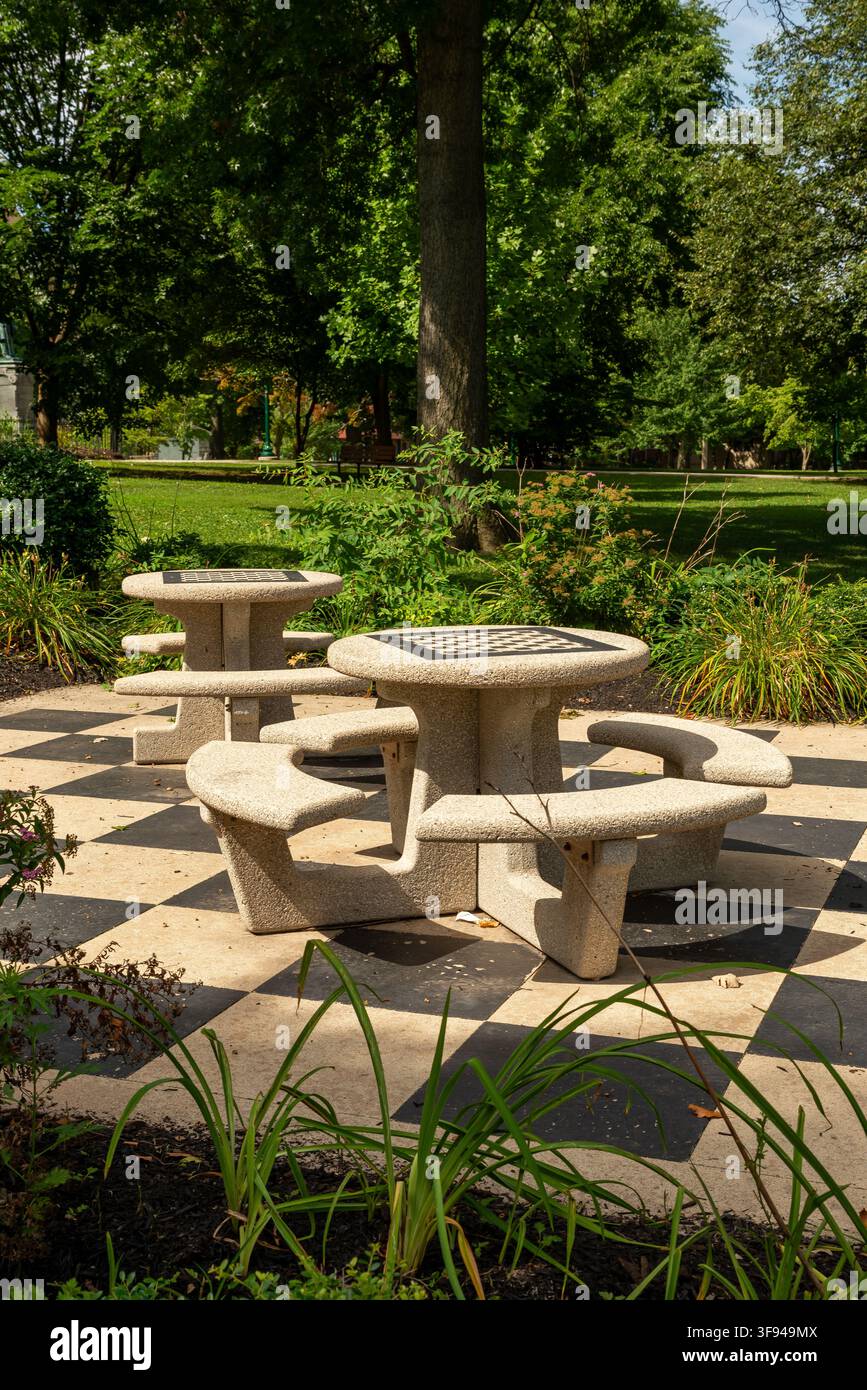 Tavoli da scacchi all'aperto posizionati in giardini paesaggistici e alberi maturi al Reeves Park di Phoenixville, Pennsylvania. Foto Stock
