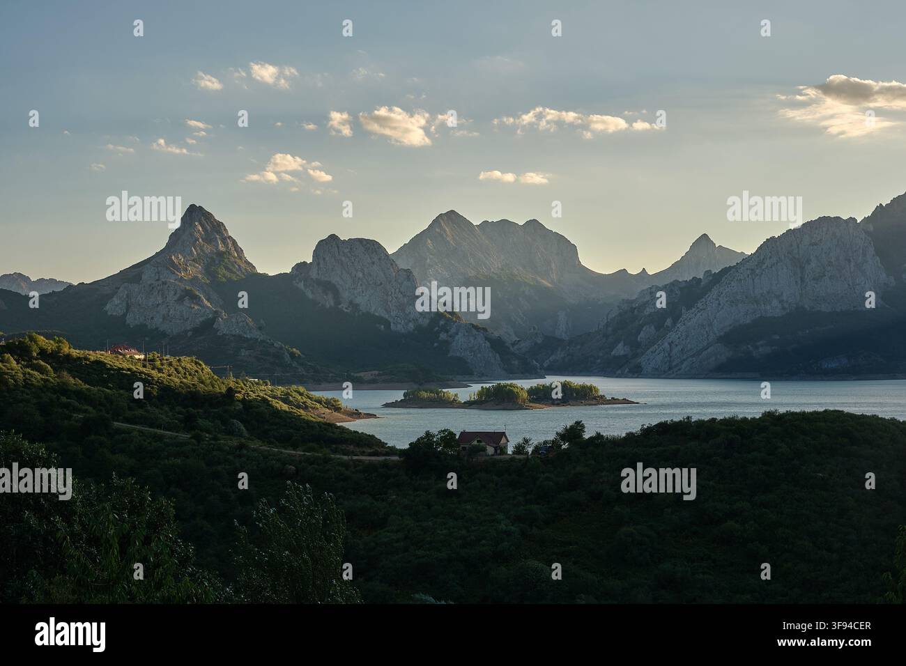 Un paesaggio di un rifugio circondato da montagne frastagliate, situato sulla riva di un lago. Il posto perfetto per trascorrere una vacanza. Foto Stock