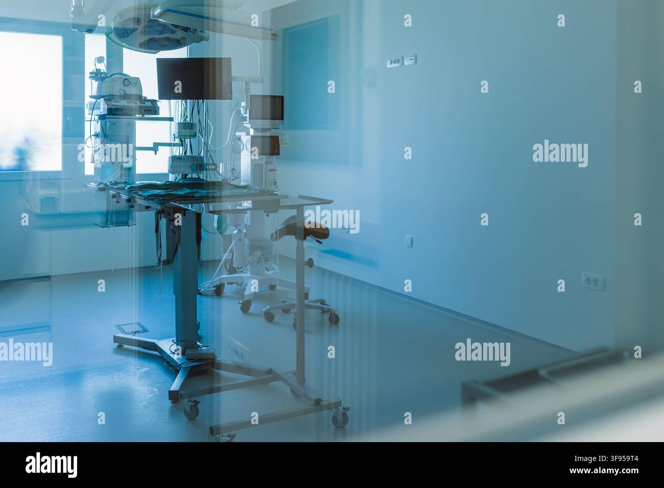Una sala operatoria in un ospedale mostra apparecchiature mediche allestite per un intervento. La stanza appare pronta per l'uso durante il giorno. Foto Stock