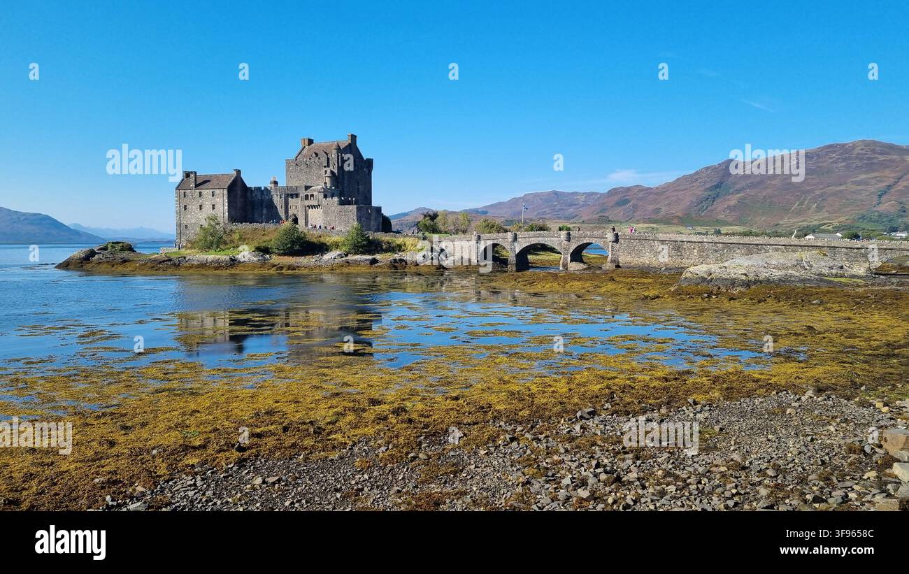 Castello di Eilean Donan con montagne e acque tidali vicino a Kyle of Lochalsh, Highlands scozzesi, Scozia. Foto Stock