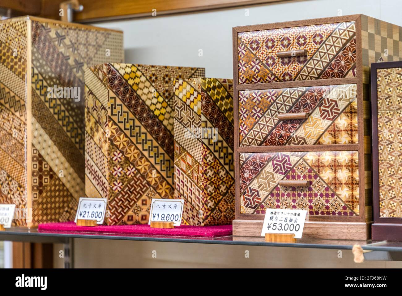 Le scatole di legno Yosegi Zaiku con motivi geometrici tradizionali sono esposte in un negozio vicino a Hakone, Prefettura di Kanagawa, Giappone. A Hakone, tali scatole sono spesso realizzate come "Himitsu-Bako", scatole rompicapo giapponesi che si aprono solo attraverso una sequenza specifica di movimenti di scorrimento. Foto Stock