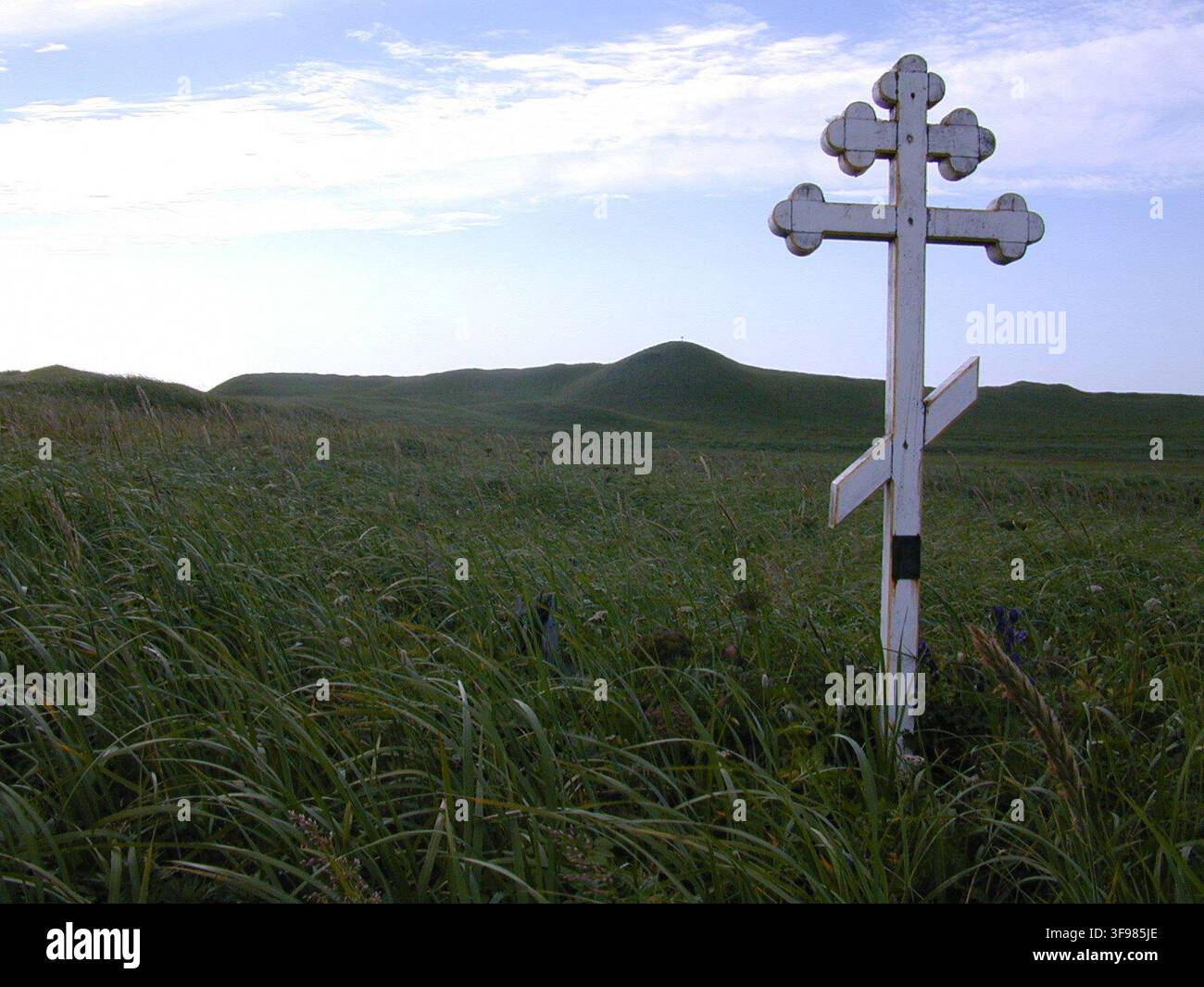 Una croce ortodossa russa in un cimitero sull'isola di St. Paul, in Alaska, fotografata il 10 agosto 2002 nell'ambito del progetto di restauro delle isole Pribilof, con la croce che presenta due barre orizzontali e una diagonale che incrociano un palo verticale, simboleggiando il segno sopra la testa di Cristo, le sue braccia distese e il poggiapiedi che sostiene il suo corpo. Foto Stock