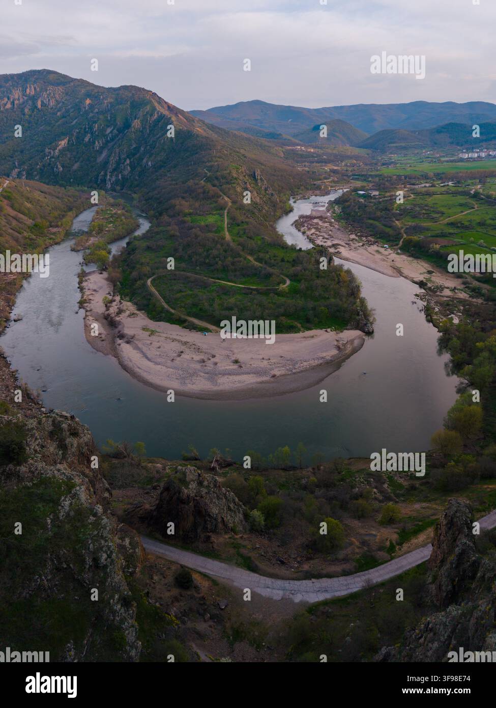 Prospettiva aerea che mostra le curve notevoli del fiume Arda mentre scorre attraverso le valli vivaci vicino a Madzharovo. Le colline circostanti sono rigogliose e verdi, creando una scena pittoresca. Foto Stock